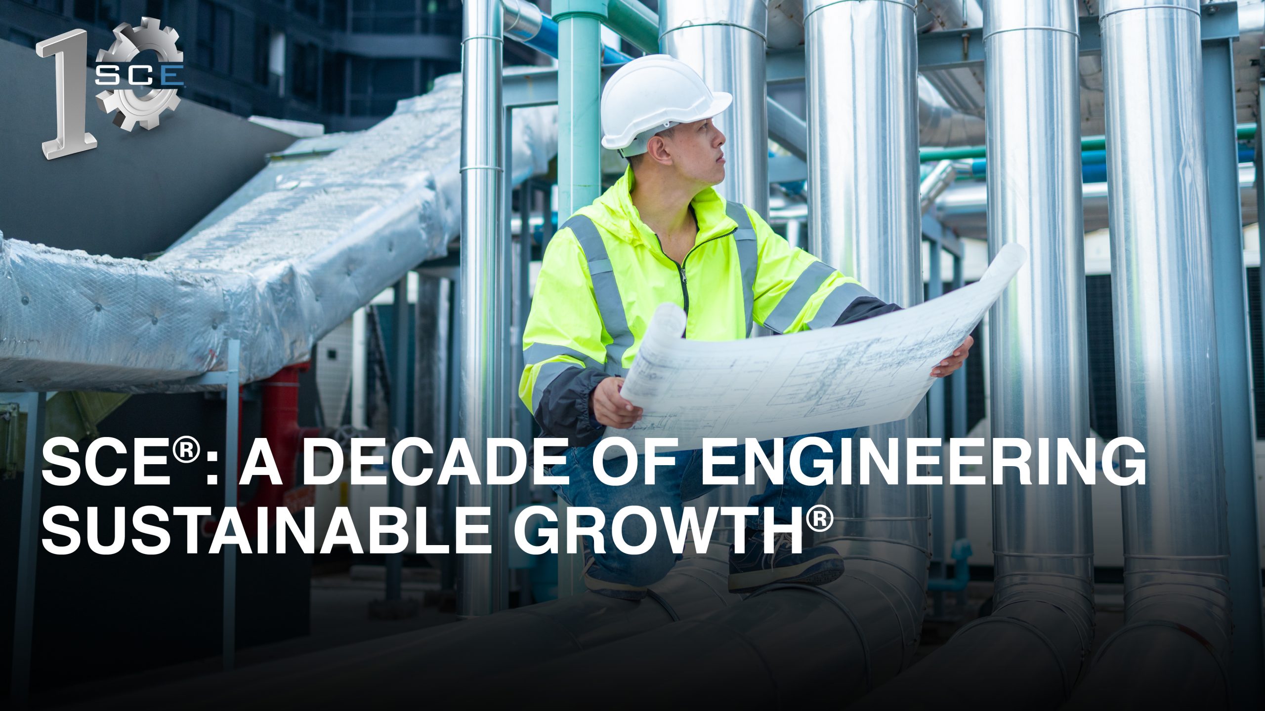 Engineer in high-visibility gear reviews blueprints inside an industrial facility, representing SCE®’s decade of sustainable HVAC engineering.